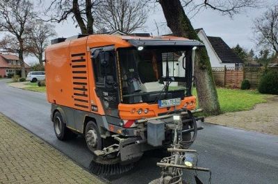 Straßenkehrmaschine reinigt Straßenrand