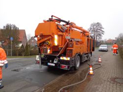 Orangefarbenes Kanlreinigungsfahrzeug auf Straße